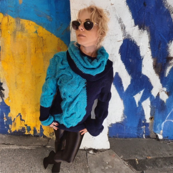 Cozy woman’s sweater featuring a large collar transformable into a hood