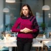Contemporary artistic knit in deep plum with cape-style asymmetric sleeve.